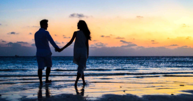 Relacionamentos pelo ponto de vista de Ifa. Casal anda de mãos dadas na praia no pôr do sol.